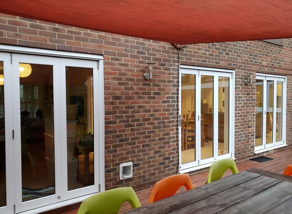 White timber bifold doors installed in garage conversion Kingston upon Thames