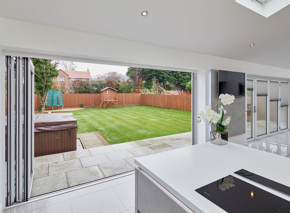 Open Supreme 3.6M White aluminium Bifold doors shows garden view