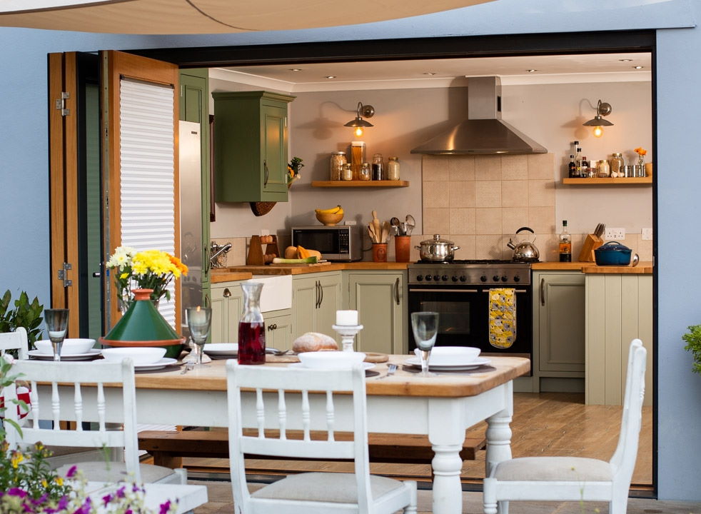 Outside open Ultra 2.7M grey bifold doors with a view into the kitchen