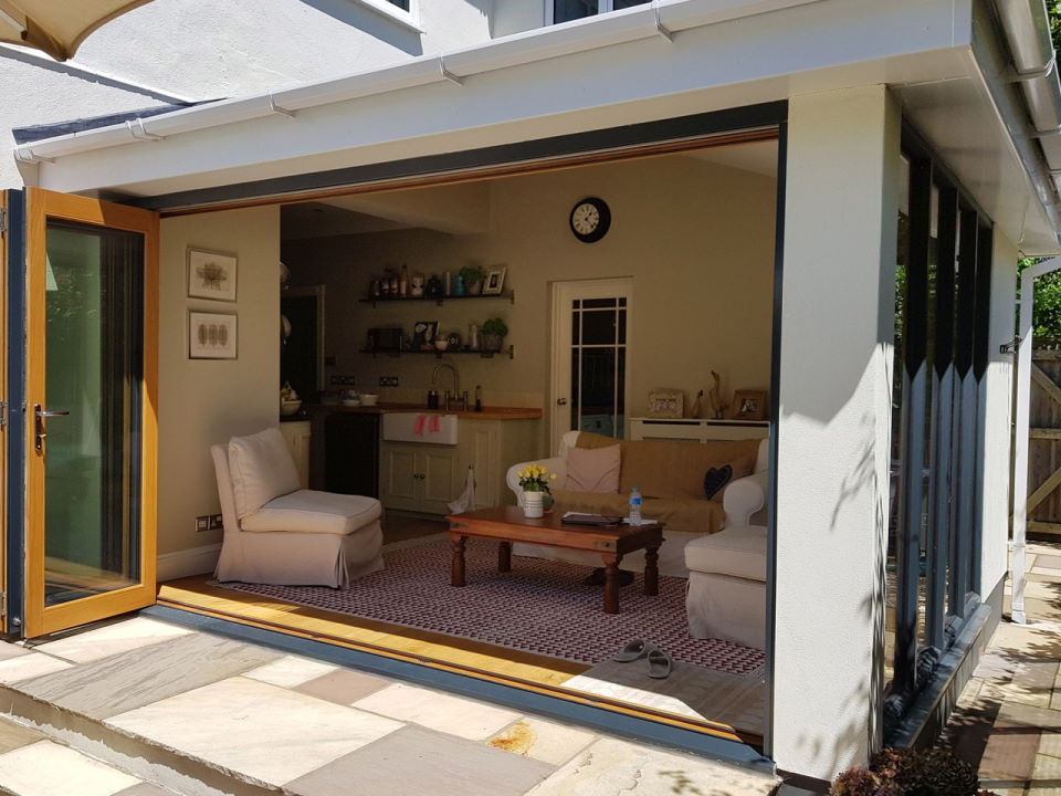 Outside view, open Ultra Grey 3.6M bifold doors and Ultra bespoke window