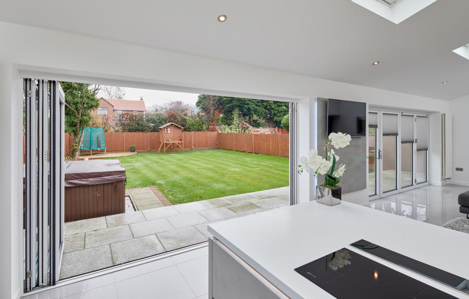 Open Supreme 3.6M White aluminium Bifold doors shows garden view