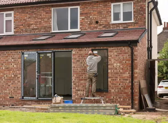 Anthracite aluminium bifold doors getting installed on a 1930s house extension