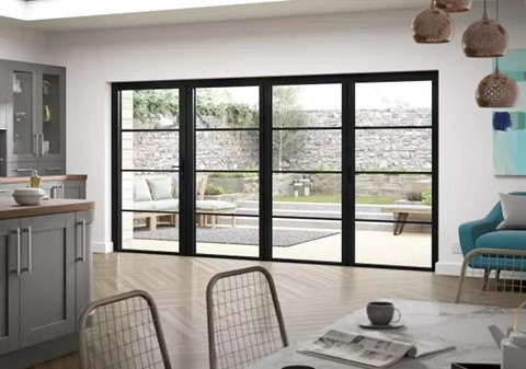 Large 4 panel bifold doors within a kitchen with a dining table and chairs in the foreground